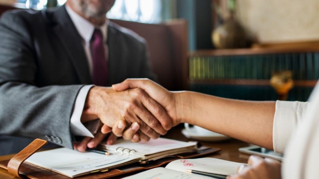 Dos persona dándose la mano en una negociación extrajudicial del proceso de la demanda colectiva Puretech